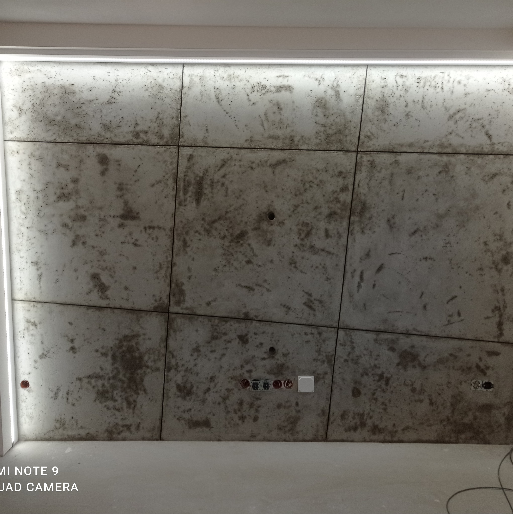 Betonowa sufitowa okładzina dekoracyjna z widocznymi puszkami elektrycznymi i oświetleniem LED w szczelinie