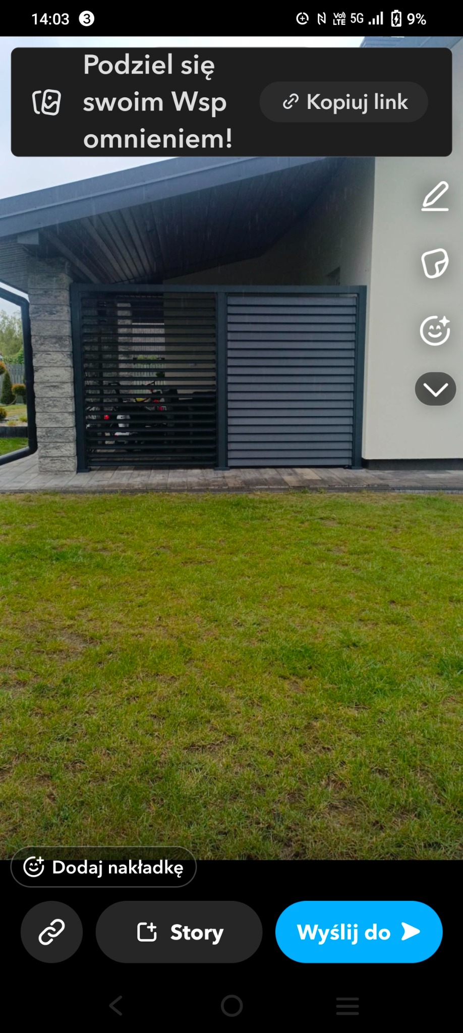 Nowoczesna, pozioma brama lamelowa w kolorze antracytowym, z widocznym samochodem w tle. Brama zamontowana przy jasnym budynku z elementami kamiennymi.