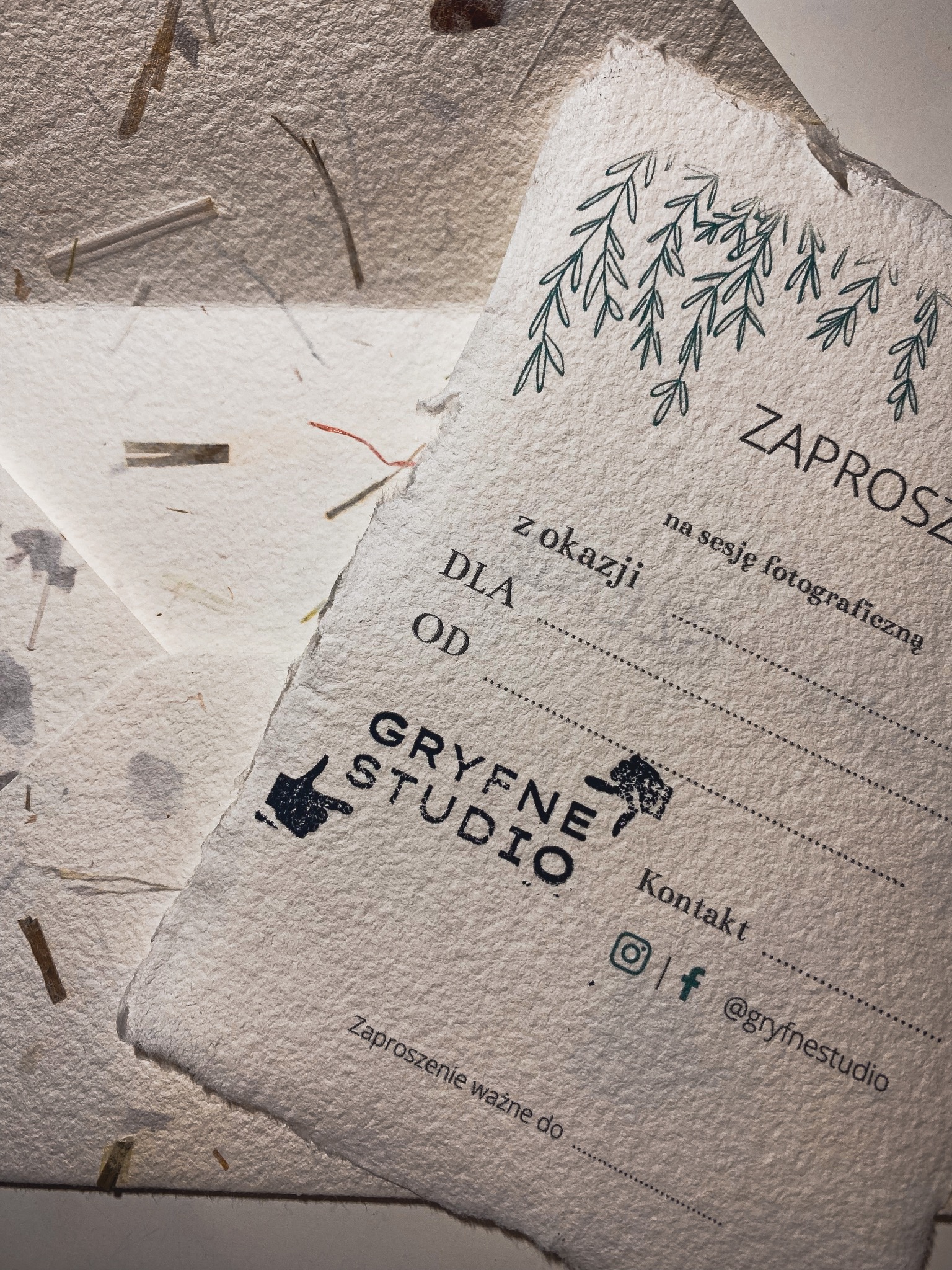 Zaproszenie na sesję fotograficzną od Gryfne Studio na papierze czerpanym z dodatkiem roślinnym, widoczne logo i dane kontaktowe.