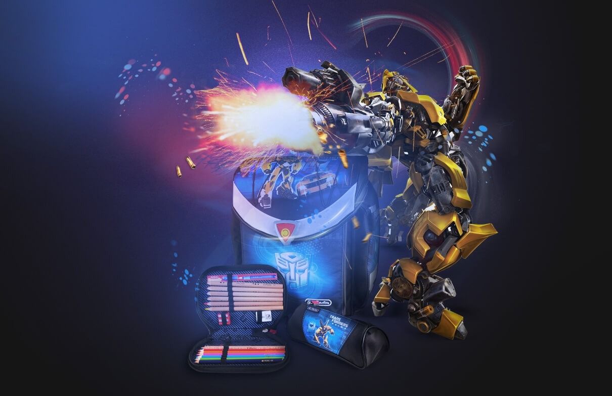 Plecak szkolny, piórnik z kredkami i tuba na długopisy z motywem Transformers, otoczone efektami specjalnymi imitującymi strzelanie i wybuchy.
