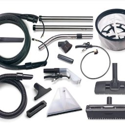 Perfekcyjne Sprzątanie MAŁGORZATA WRÓBEL - Zestaw akcesoriów do odkurzacza piorącego, w tym różne dysze, węże, rury i zbiornik na wodę, ułożone na białym tle.
