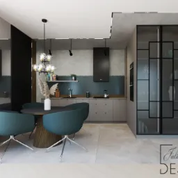 Wizualizacja nowoczesnej kuchni z jadalnią: okrągły stół z turkusowymi krzesłami, szara zabudowa kuchenna z niebieskim akcentem nad blatem, przeszklona witryna z czarnymi ramami.