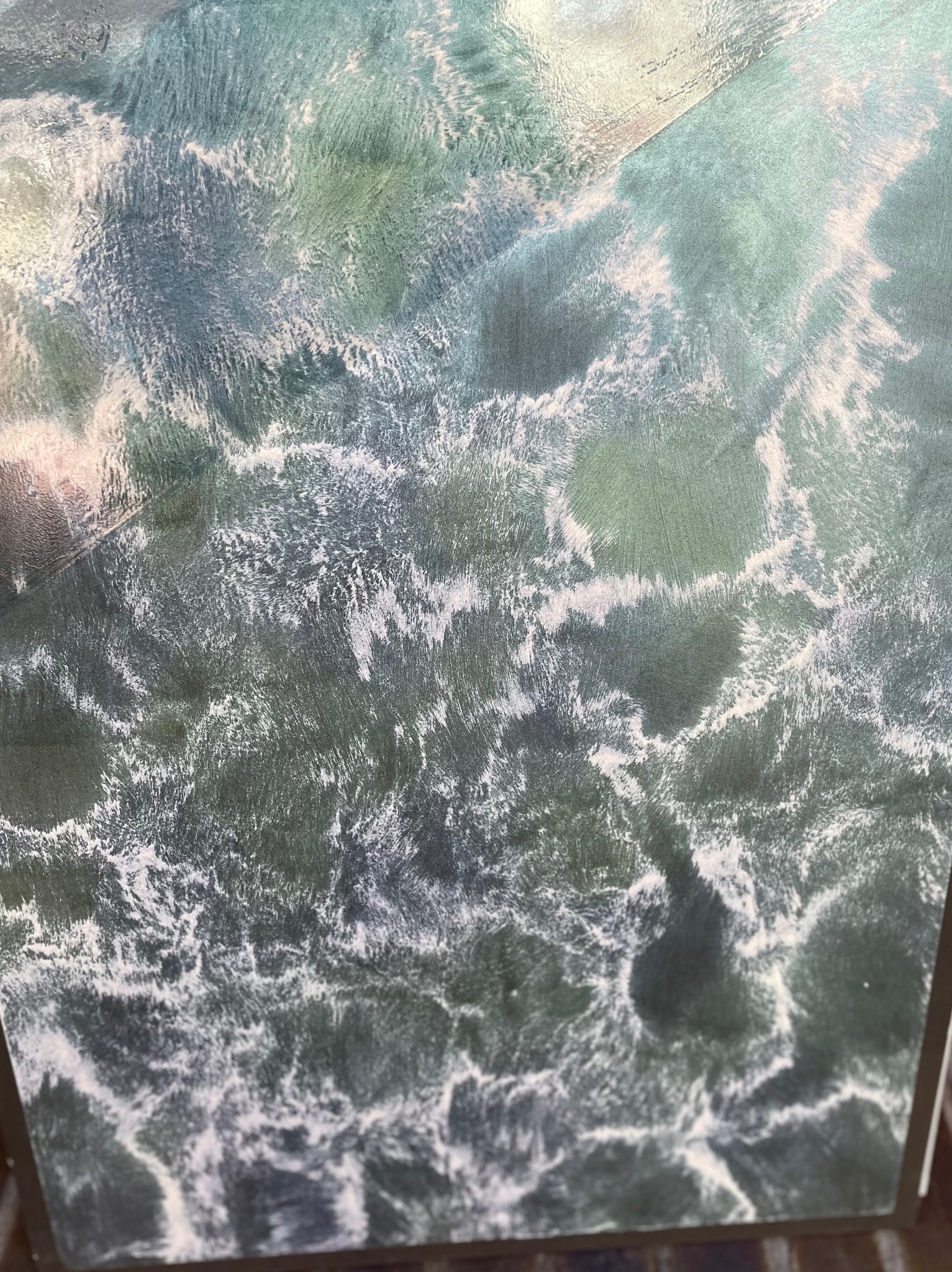 Świeżo nałożony, dekoracyjny tynk strukturalny w odcieniach zieleni i bieli, imitujący wzburzone morze, zbliżenie na fragment ściany.