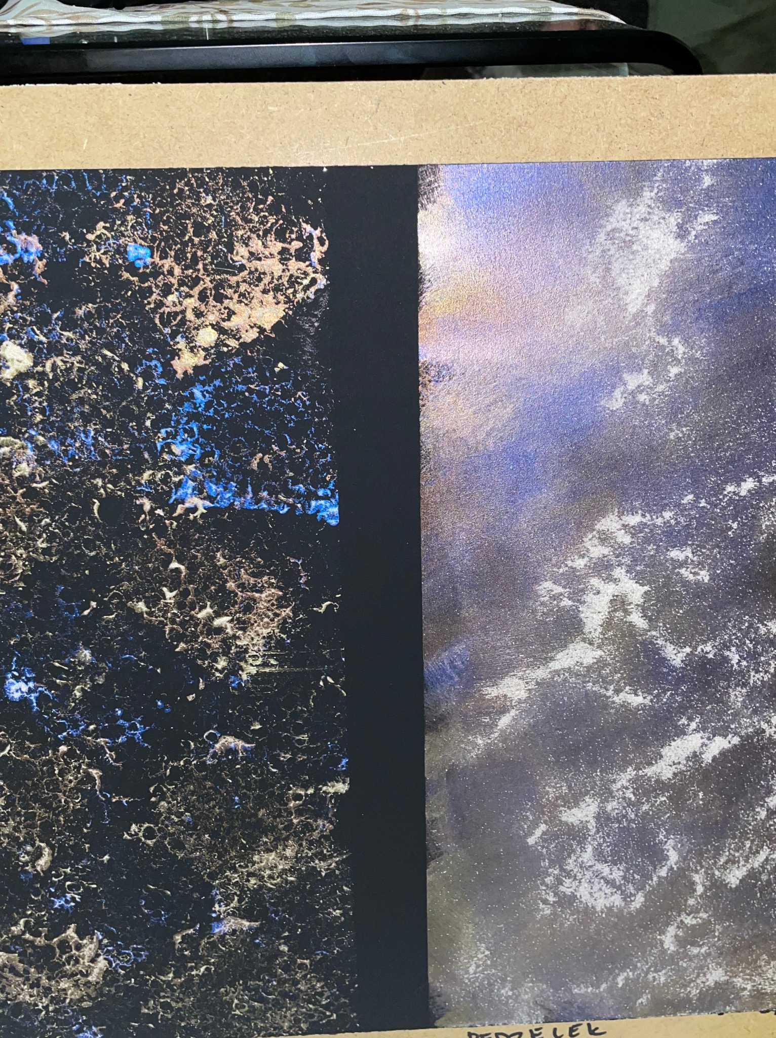 Próbka dwóch rodzajów strukturalnego wykończenia ściany: po lewej ciemna, porowata powierzchnia z niebieskimi i złotymi akcentami, po prawej jaśniejsza, opalizująca powierzchnia z białymi smugami.