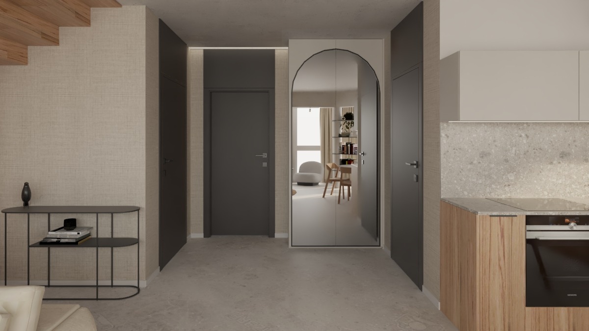 Wnętrze mieszkania w neutralnych barwach z widocznym fragmentem kuchni, konsolą z dekoracjami, drzwiami i lustrem w łukowej ramie, odbijającym dalszą część pomieszczenia z krzesłami i regałem.