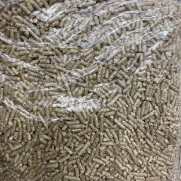 Przezroczysty worek wypełniony szarym, drobnym granulatem opału, widoczne zagniecenia i załamania folii.