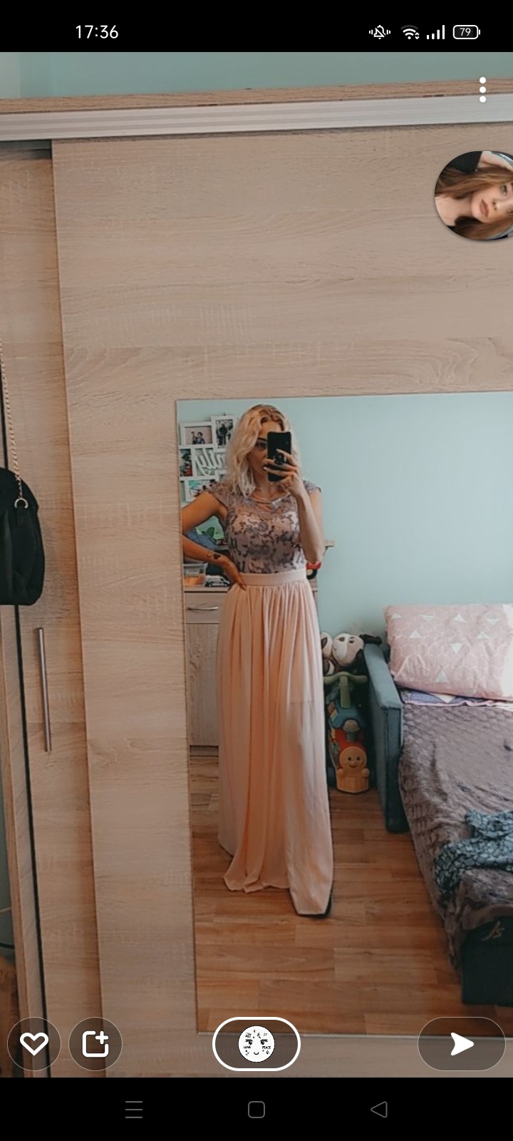 Kobieta robi selfie w lustrze, ubrana w długą, plisowaną, brzoskwiniową spódnicę i koronkową bluzkę. W tle widoczna szafa z przesuwnymi drzwiami i łóżko z pluszakami.