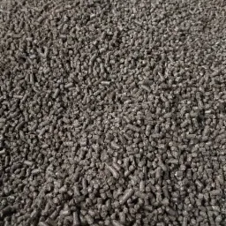 Worek wypełniony ciemnymi granulkami opału, widoczne włókna worka w dolnej części kadru.