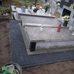 Układanie kostki brukowej wokół nagrobków.
