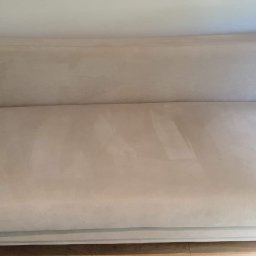 Clean-Pro - Jasna kanapa z widocznymi śladami czyszczenia na siedzisku, ukazująca efekt usługi.