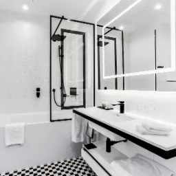 Elegancka łazienka w czarno-białej kolorystyce z wanną, kabiną prysznicową typu walk-in z czarną armaturą i umywalką z podświetlanym lustrem, wykończona płytkami o zróżnicowanej fakturze.