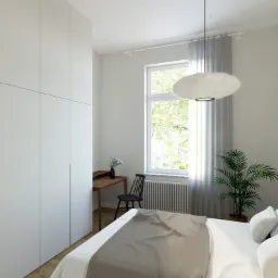 Jasna sypialnia z minimalistyczną białą szafą w zabudowie, biurkiem z krzesłem przy oknie i wiszącą lampą w kształcie owalu.