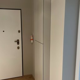 GutArt Radosław Gut - Montaż szafy wnękowej w przedpokoju, widoczny odkurzacz przemysłowy i zabezpieczenia podłogi.