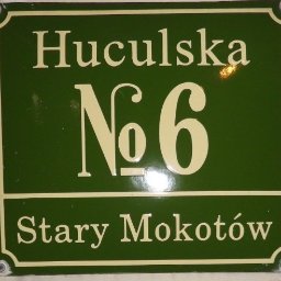 Sprawdzony Detektyw - Zielona tabliczka z adresem 'Huculska No 6, Stary Mokotów' w kremowych literach, przymocowana śrubami.