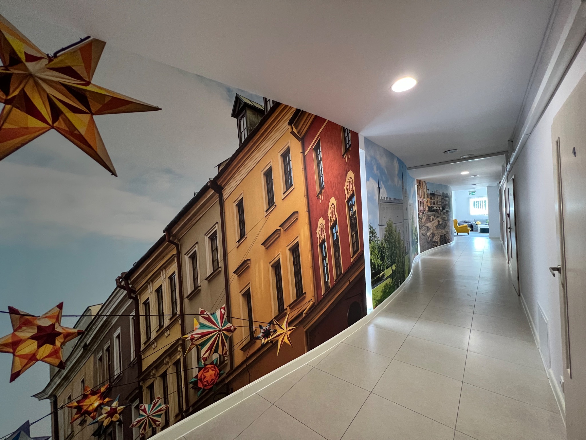 Korytarz z fototapetą przedstawiającą uliczkę starego miasta z dekoracyjnymi gwiazdami, dodatkowo pomalowanymi na suficie