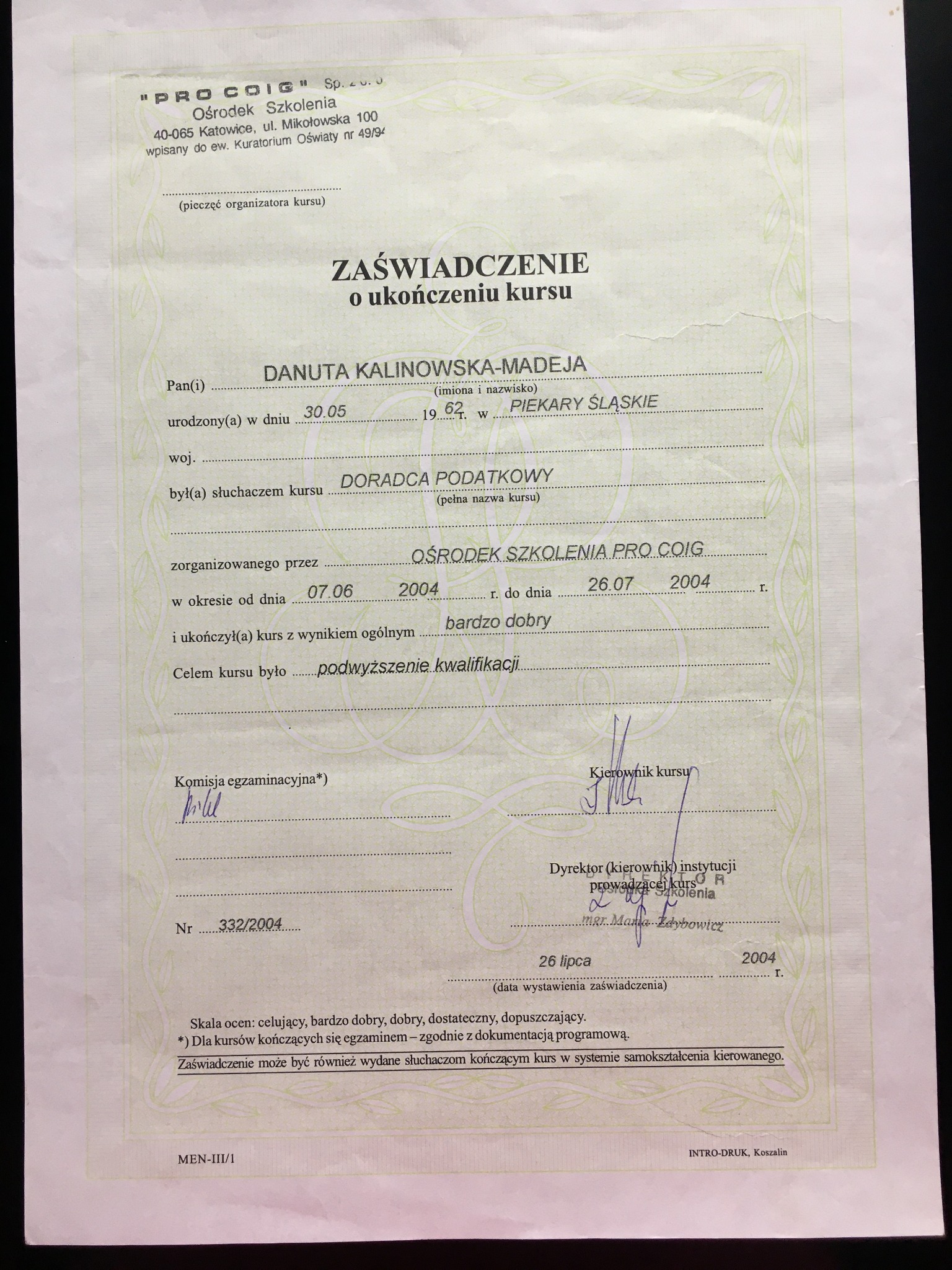 Skan zaświadczenia o ukończeniu kursu dla Doradcy Podatkowego, wystawionego przez Ośrodek Szkolenia PRO COIG, z datą 26 lipca 2004 roku, z pieczęciami i podpisami.