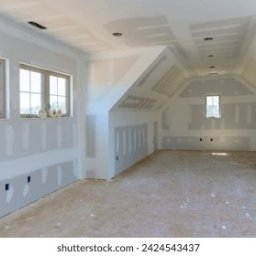 Profi - Poddasze w trakcie wykańczania: ściany i sufit pokryte szpachlą, widoczne okna i instalacje elektryczne. Przygotowanie do malowania.