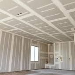 Profi - Wykończone płyty gipsowo-kartonowe na ścianach i suficie w jasnym wnętrzu, przygotowane do dalszych prac wykończeniowych, widok na okno i otwór drzwiowy.