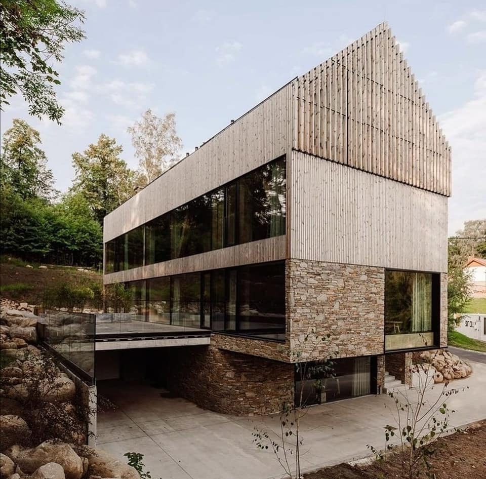 Nowoczesny dom z elewacją z drewna i kamienia, duże okna, widok na zieleń, Karpacz. Apartamenty Wilcza Forrest.