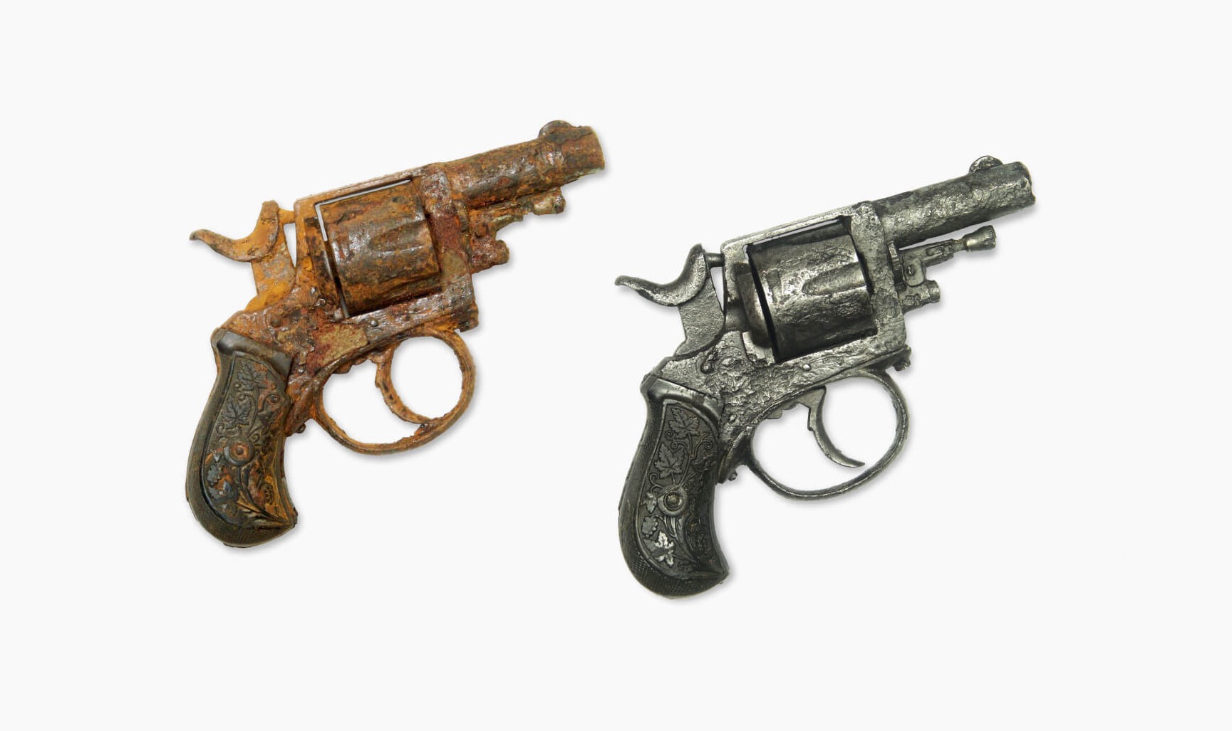 Porównanie dwóch rewolwerów centralnego zapłonu: jeden silnie skorodowany, drugi po renowacji, ukazujący detale zdobień na rękojeści.