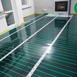 FOLIE GRZEWCZE, MATY -  Arkadiusz Zawadzki - Montaż folii grzewczej pod wylewkę w nowym mieszkaniu w Warszawie, widoczne taśmy mocujące i przygotowane podłączenie elektryczne.