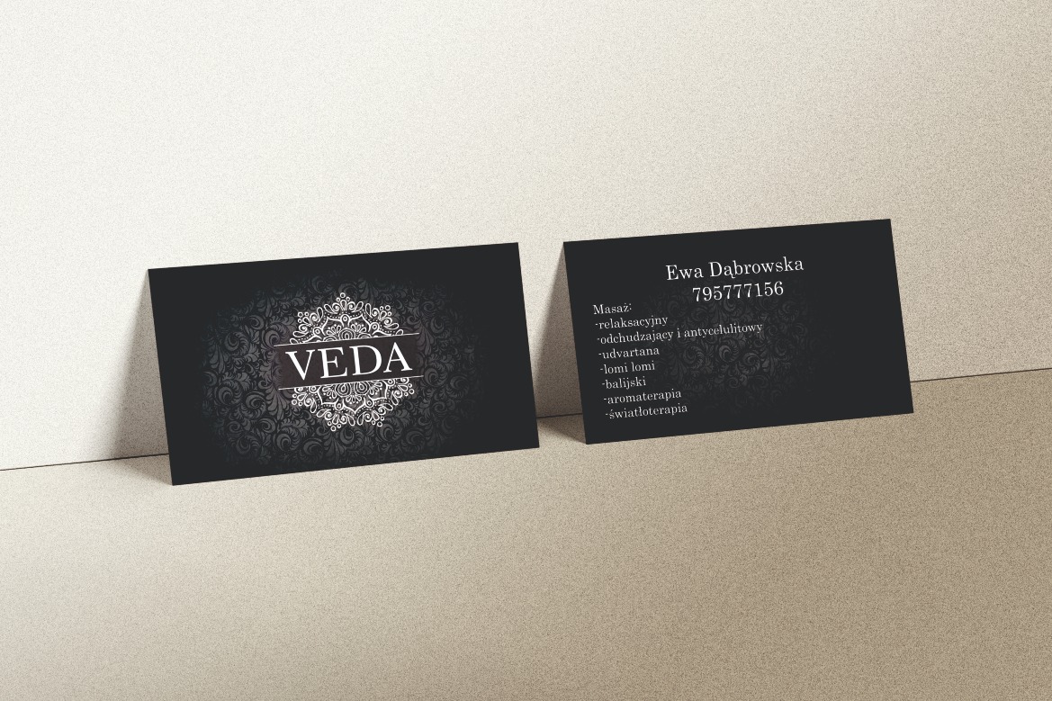 Dwie czarne wizytówki z logo Veda i danymi kontaktowymi Ewy Dąbrowskiej, leżące na beżowym tle. Na jednej wizytówce widoczne logo firmy, na drugiej dane kontaktowe i lista oferowanych masaży.