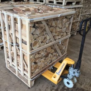 Klatka z drewnem opałowym, pocięte kawałki ułożone równo, transportowane w Wierzycach wózkiem paletowym.