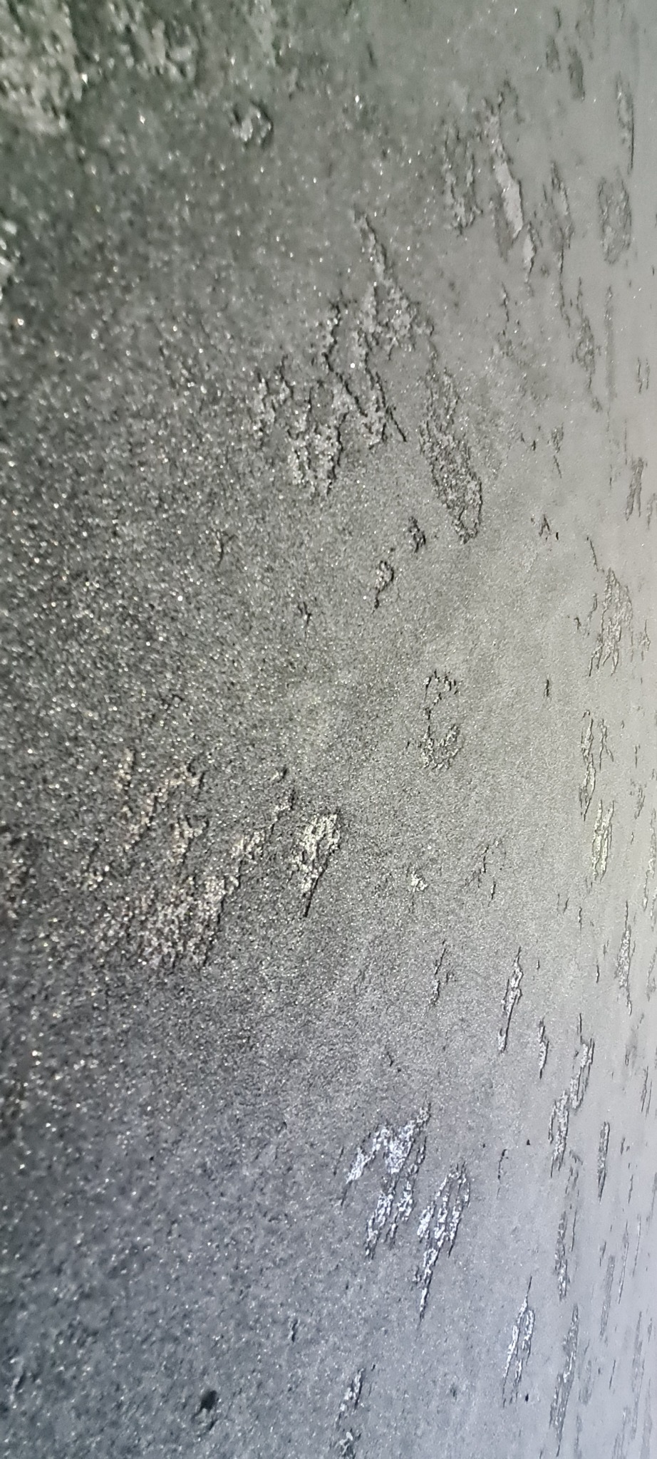 Dekoracyjna, szara ściana z efektem onyksu, z wyraźną fakturą i delikatnym połyskiem, sfotografowana pod kątem.