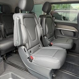 MBVBUS - Wnętrze luksusowego busa z szarymi skórzanymi fotelami na szynach, widok z boku. Komfortowy przewóz osób w Ząbkach.