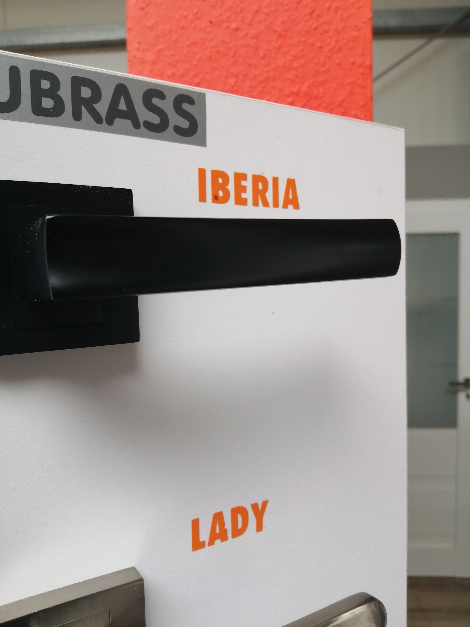 Ekspozycja klamek do drzwi wewnętrznych z czarną, prostokątną klamką marki IBERIA LADY na białym tle z widocznym logo JBRASS.