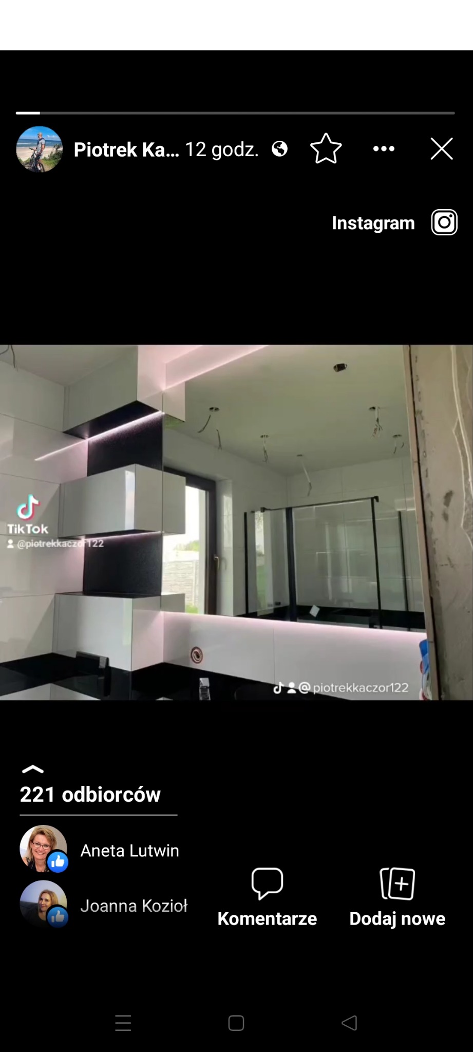 Nowoczesna łazienka w trakcie wykańczania z czarno-białą zabudową meblową, podświetleniem LED i szklaną kabiną prysznicową, widoczne niedokończone instalacje elektryczne.