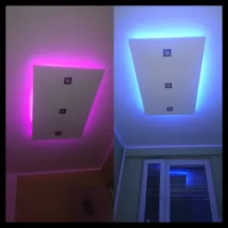 Dwa ujęcia sufitu podwieszanego z oświetleniem LED: po lewej różowe, po prawej niebieskie, z trzema punktowymi lampami w każdym ujęciu.