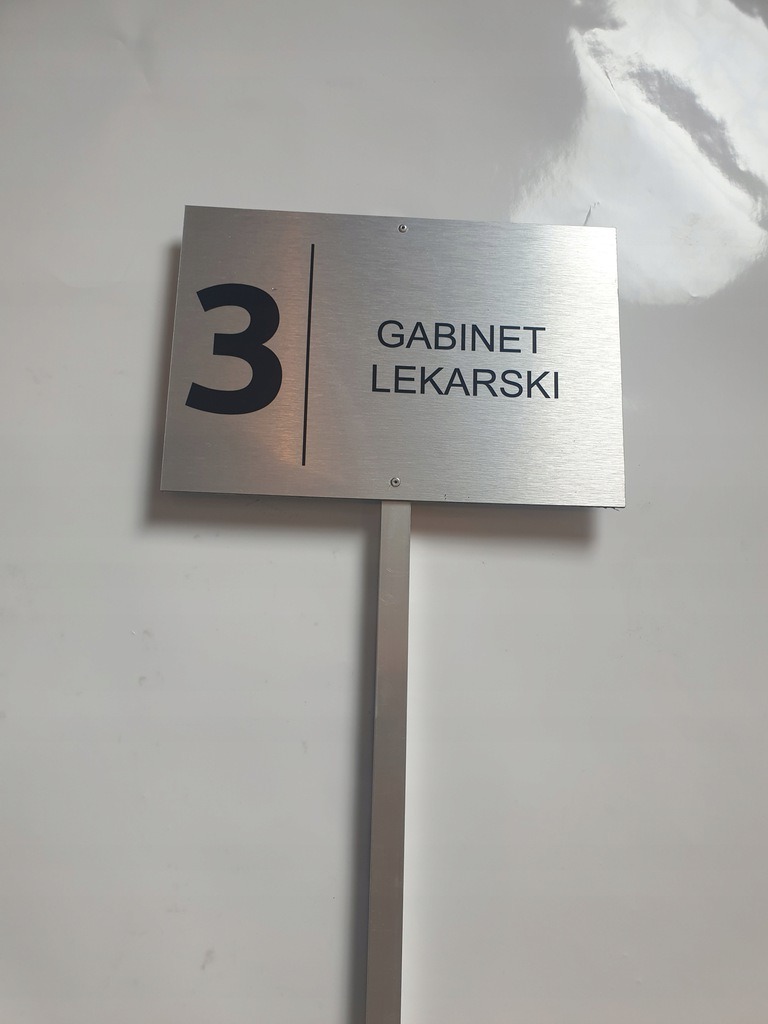 Metalowa tabliczka informacyjna z numerem '3' i napisem 'GABINET LEKARSKI' na białej ścianie, wykonana w Gliwicach.