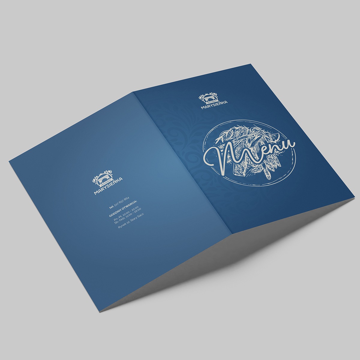 Otwarta, niebieska teczka z logo i menu restauracji Marysieńka, prezentowana pod kątem na szarym tle.