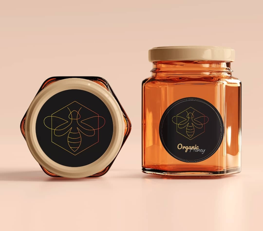 Dwa słoiki z miodem ekologicznym, jeden zamknięty i ustawiony pod kątem, drugi z etykietą na boku, prezentacja produktu na gładkim tle.