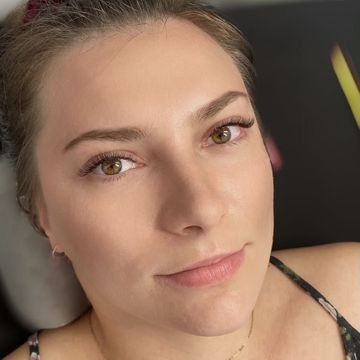 Portret kobiety z delikatnym makijażem oczu, w tym przedłużonymi rzęsami, wykonanym w Toruniu. Widoczne subtelne podkreślenie brwi i naturalny odcień skóry.