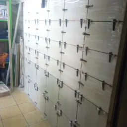 Montaż płyt kartonowo-gipsowych na ścianie z użyciem poziomicy i klipsów dystansowych, widoczne instalacje pod sufitem