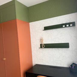 DREAM HOUSE BUILDING VALERII SAVCHUK - Pokój po remoncie: szafa w odcieniach pomarańczy i zieleni, półki z dekoracjami na ścianie w globusy, czarne biurko. Nowoczesny design i dbałość o detale.