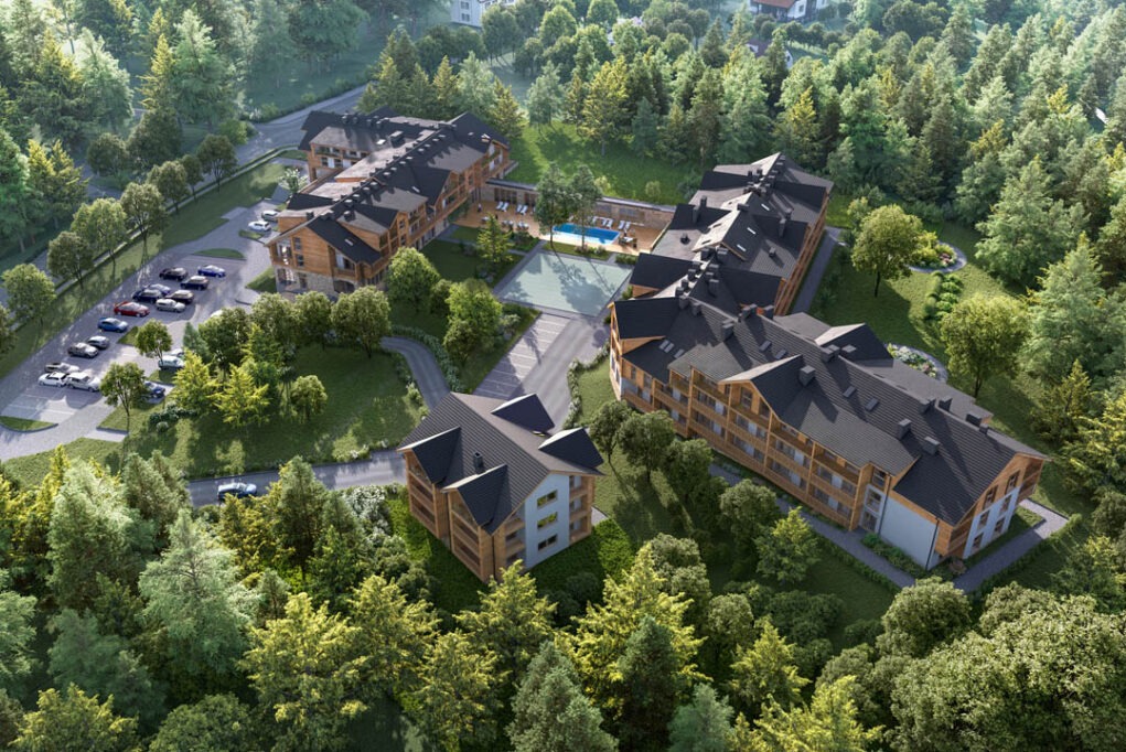 Wizualizacja z lotu ptaka kompleksu budynków z ciemnymi dachami, drewnianymi elewacjami i basenem, otoczonego zielenią drzew. Widoczny parking i droga dojazdowa.
