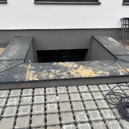 Ślusarstwo-Spawalnictwo Artem Sidorenko - Montaż zejścia do piwnicy z metalową obudową w Łodzi, widoczne ułożone kostki brukowe i przewód elektryczny.