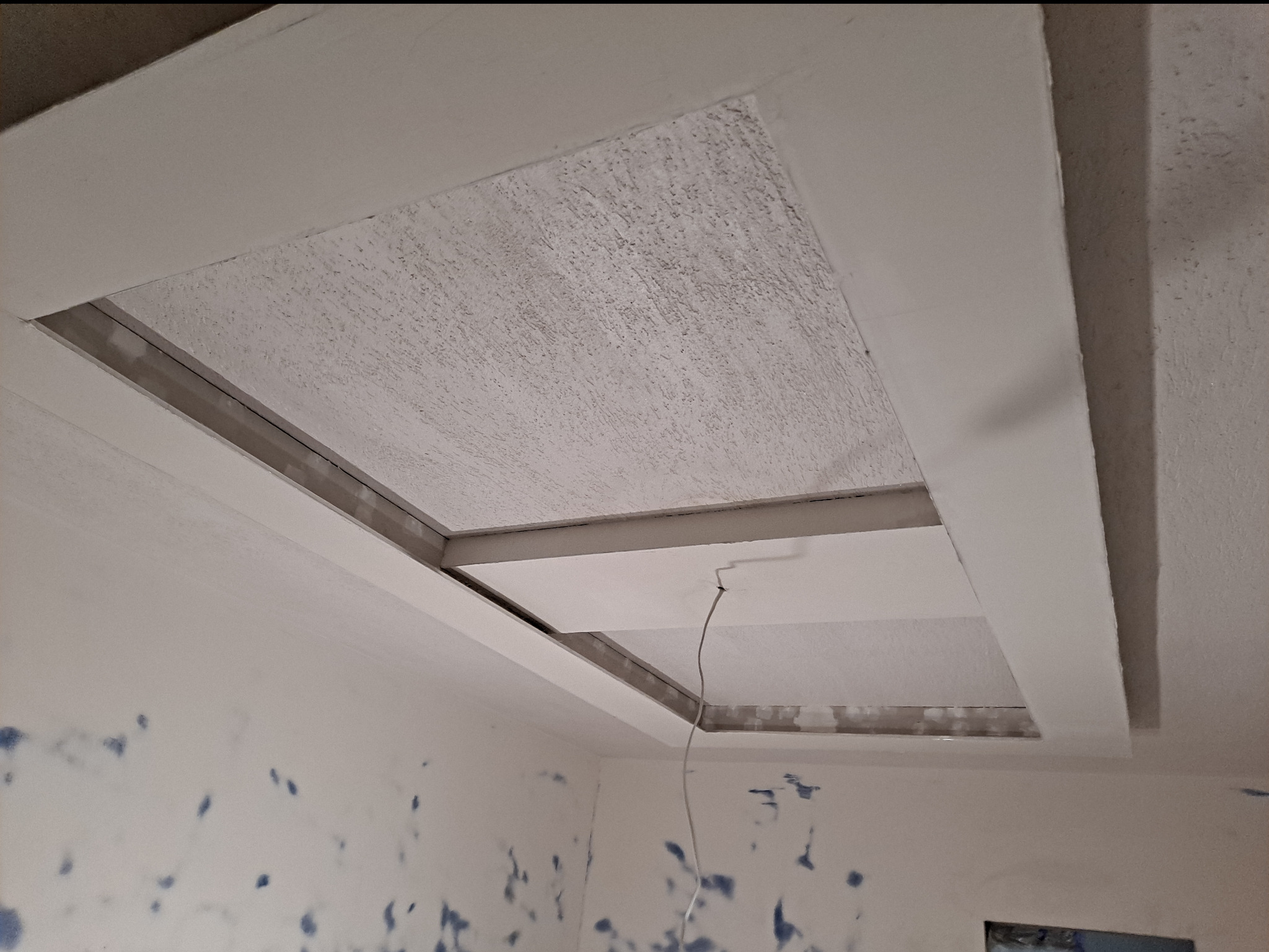 Kasetonowy sufit podwieszany z oświetleniem w trakcie montażu w Jaroszowicach, widoczne przewody i ślady po pracach na ścianach.