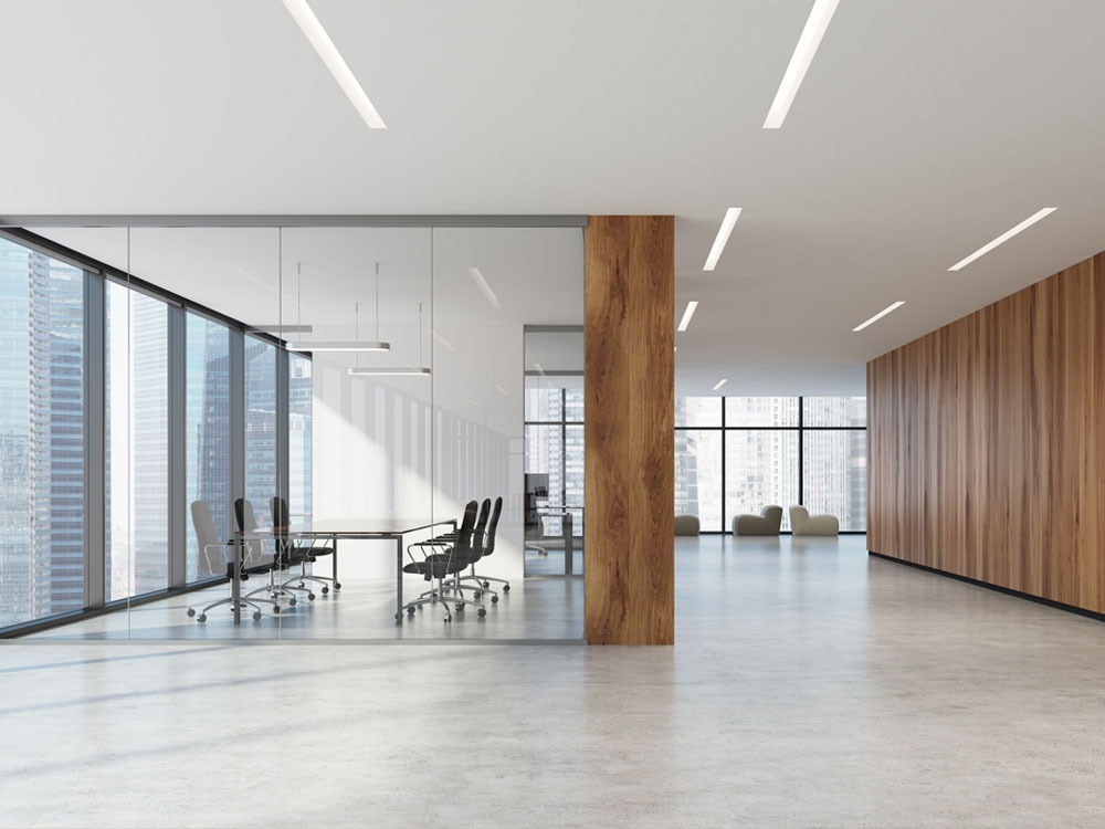 Nowoczesne biuro z podłogą o jasnoszarym, betonowym wykończeniu, szklaną salą konferencyjną i drewnianymi panelami ściennymi.