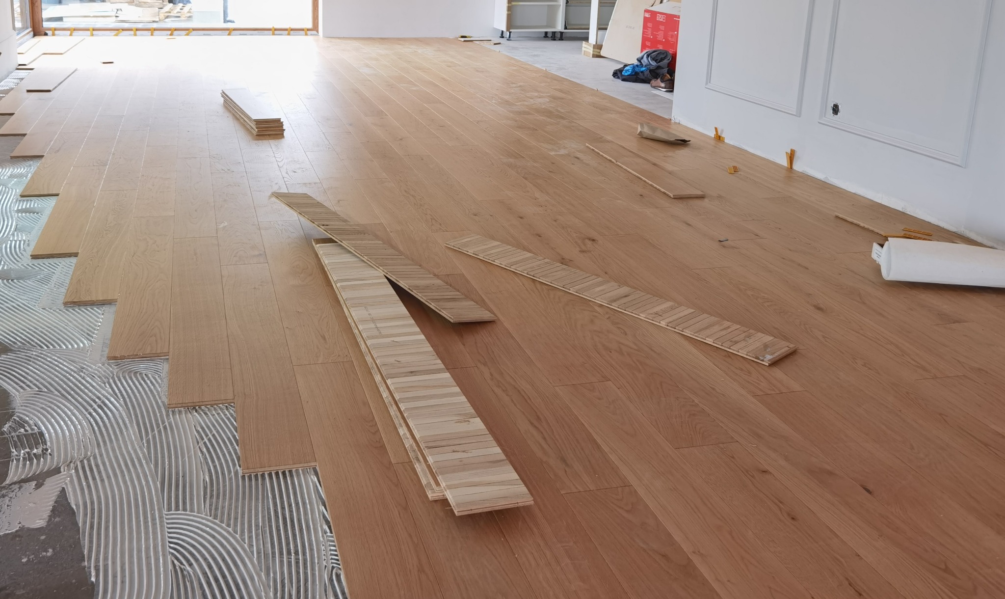 zdjęcie 1 Układanie podłogi warstwowej na ogrzewaniu podłogowym wykończonej lakierem z delikatna V fugą.