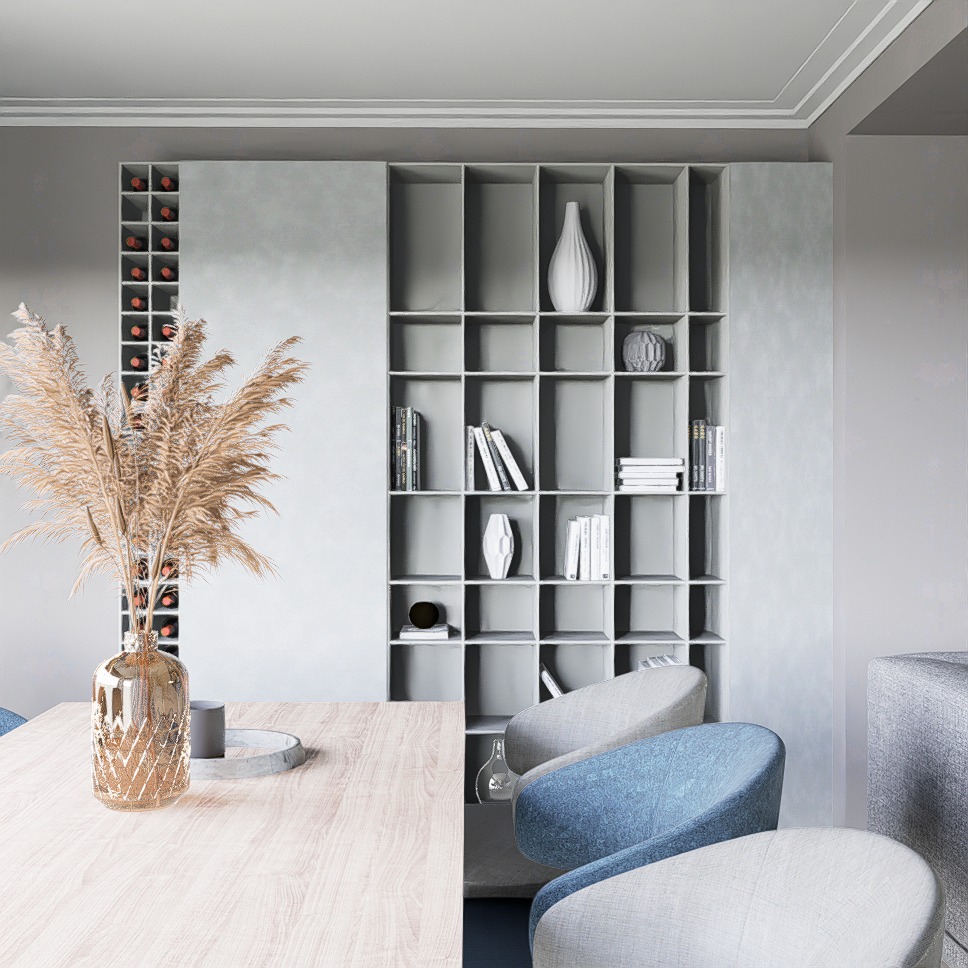 Jasne, nowoczesne wnętrze: stół z dekoracyjnym wazonem z suszem na tle szarej ściany z regałem na książki i wina, krzesła w odcieniach szarości i błękitu.