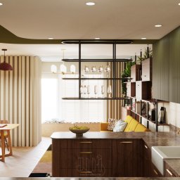 Modernointerno - Wnętrze kuchni w stylu nowoczesnym: drewniana wyspa z owocami, złota armatura, zielone szafki, oraz regał z roślinami i książkami. Światło dzienne wpada przez okno.