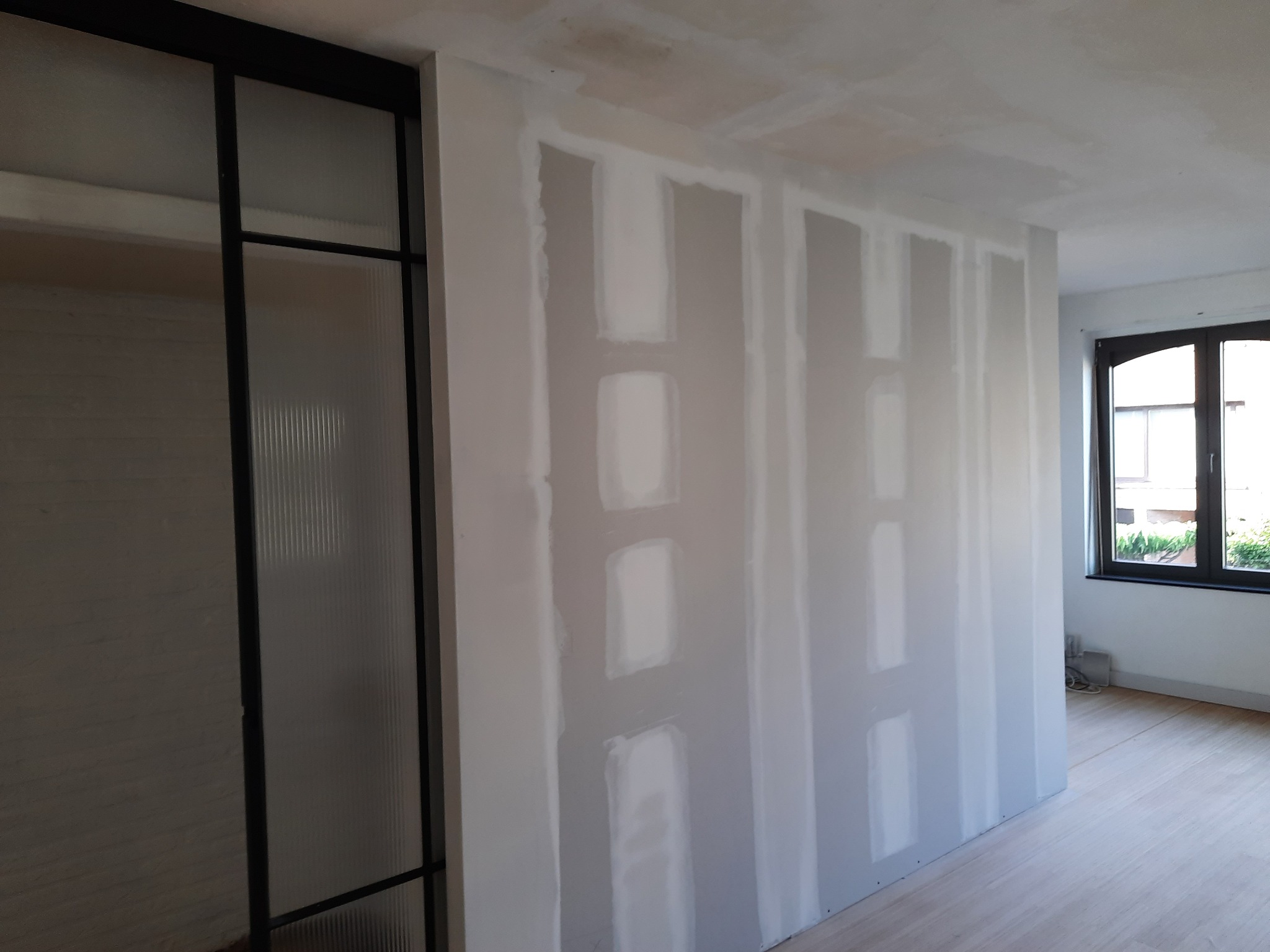 Ściana z zamontowaną płytą karton-gips w trakcie szpachlowania, widoczne łączenia, Płock.