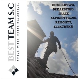 BEST TEAM s.c - Pracownik w uprzęży asekuracyjnej na dachu z drabinką dekarską, w tle błękitne niebo z chmurami i logo firmy Best Team S.C.