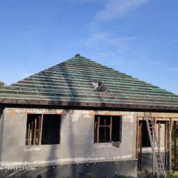 Energo-Dom - Dom w trakcie budowy, widoczny szkielet dachu z membraną Delta Vent S oraz ściany z bloczków betonowych z otworami okiennymi, drabina oparta o ścianę.