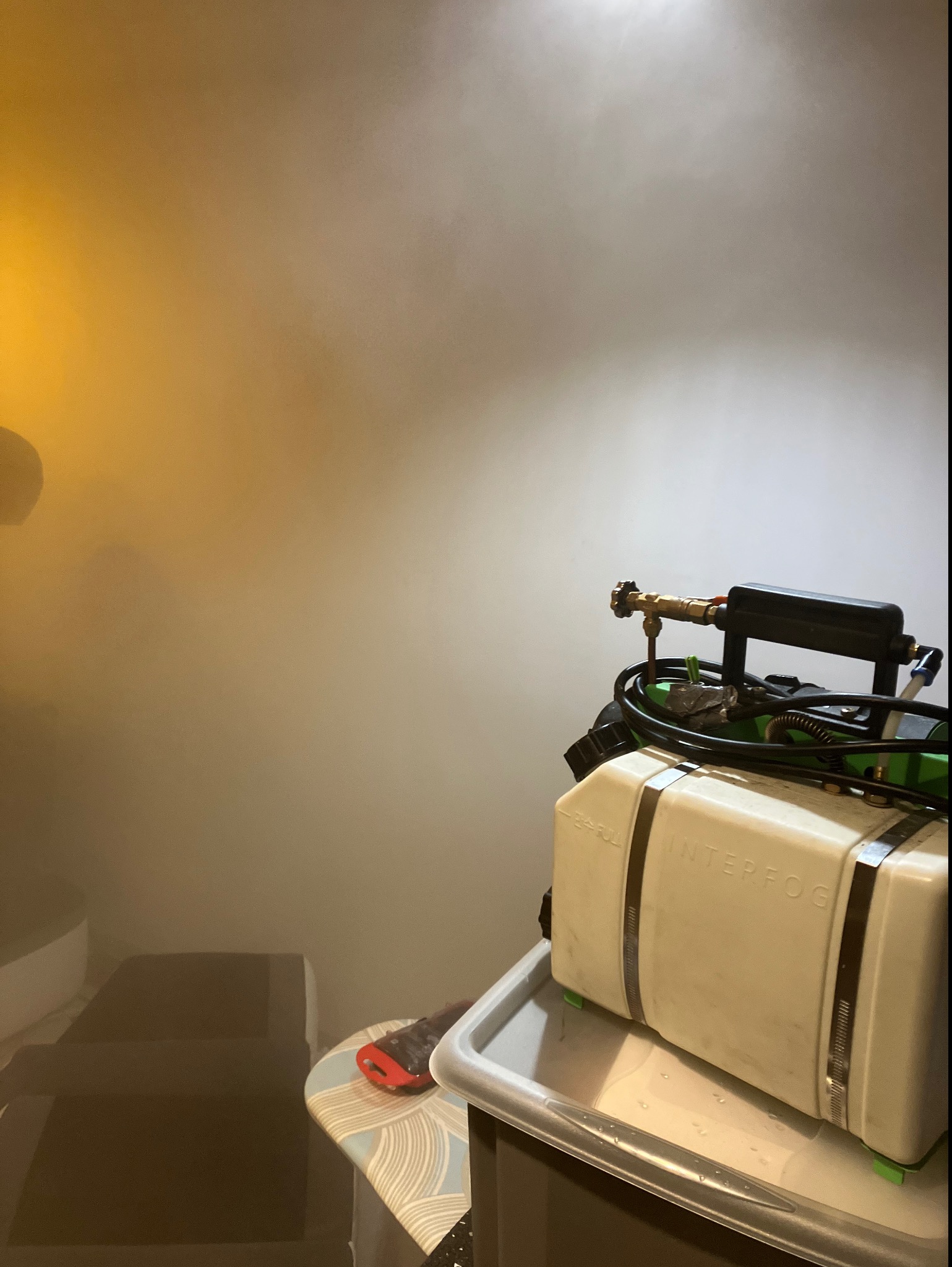 Zamglenie pomieszczenia z widocznym urządzeniem Interfog na stole, prawdopodobnie w trakcie procesu.