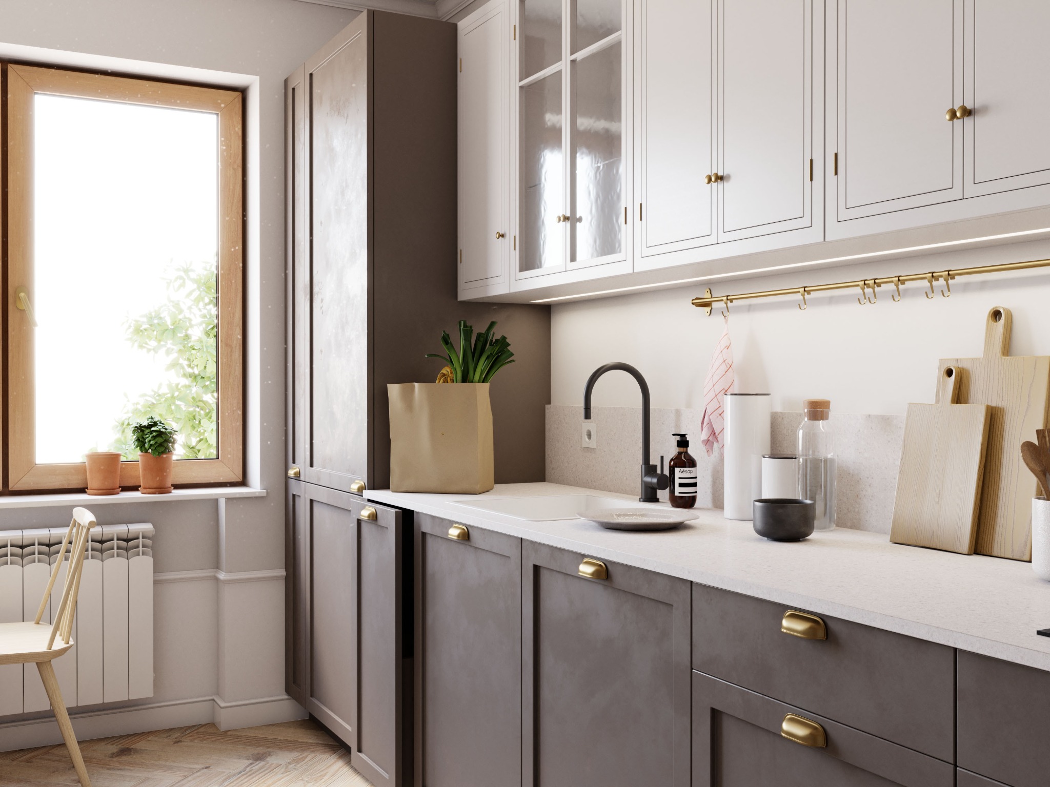 Jasna kuchnia z szarymi szafkami, złotymi uchwytami, drewnianym oknem i ziołami w papierowej torbie na blacie.